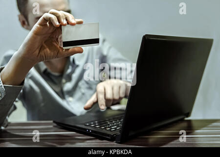Close up dei maschi di mani rendendo il pagamento on-line. Foto Stock