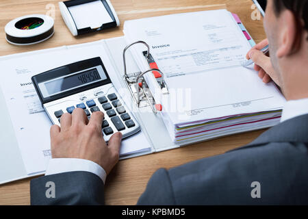 Imprenditore calcolo fattura a scrivania da ufficio Foto Stock