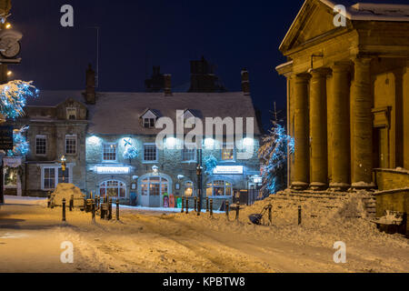 La Fox Inn in luogo di mercato di notte nella neve. Chipping Norton, Cotswolds, Oxfordshire, Inghilterra Foto Stock