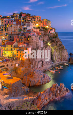 Una sera vista di lato della scogliera villaggio di Manarola, Cinque Terre Liguria, Italia, Europa. Foto Stock