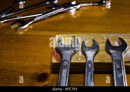 Foto orizzontale di tre grigio metallizzato di chiavi su una tavola di legno Foto Stock