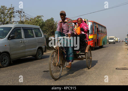 Una batteria-run rickshaw solcare le Dhaka-Aricha autostrada vicino Amin Bazar a Dhaka Foto Stock