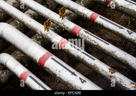 Array di vecchie tubazioni con frecce dipinte Foto Stock