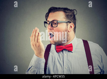 Barbuto paffuto uomo in bicchieri respirando sul braccio per il test del respiro. Foto Stock