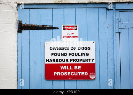 Segno su una porta di garage avvertimento che "i proprietari di cani trovati incrostazione proprietà porto' saranno perseguiti a norma di legge, Looe. Foto Stock