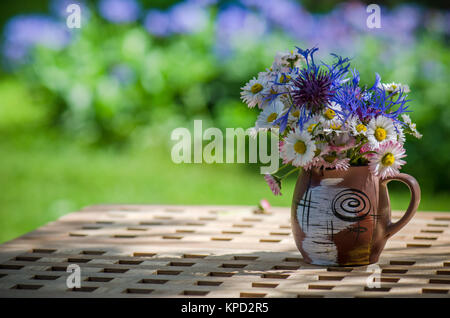 Un mazzo di fiori di campo in un cerchio sul tavolo Foto Stock