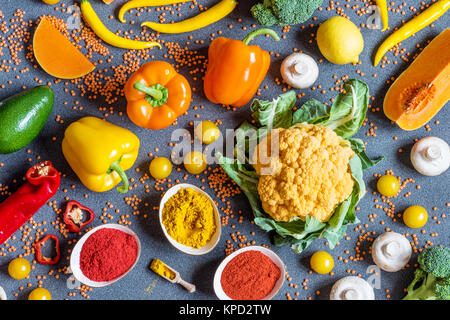 Diversi fresche verdure colorate su sfondo grigio. Appartamento laico, vista dall'alto. Foto Stock