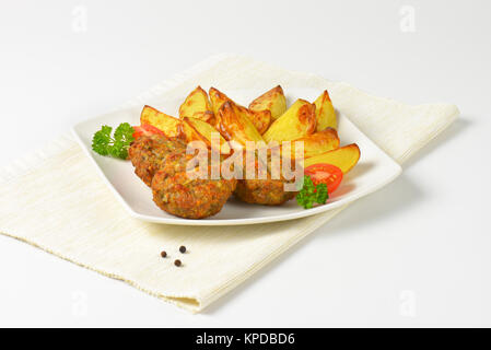 Patate arrosto e polpette fritte Foto Stock