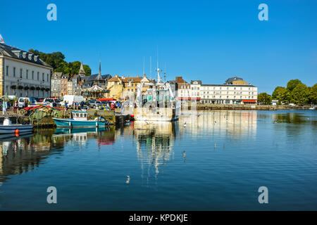 Il pittoresco porto porto di Honfleur Francia, sulla costa della Normandia, con una barca da pesca, barche più piccole, gabbiani e la giostra dietro Foto Stock