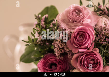 Un grande bouquet di rose in tonalità rosa giace sul tavolo in attesa di essere dato via Foto Stock