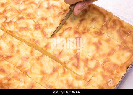 Tagliato a mano con un coltello tradizionale torta bulgara in pezzi Foto Stock