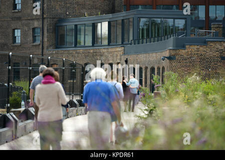 La gente camminare lungo il ristrutturato Regent's Canal Alzaia, Kings Cross, London. Foto Stock