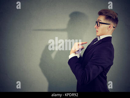 Vista laterale di uomo elegante cercando sorpreso quando viene catturato sulla menzogna. Foto Stock