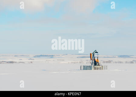 Lone Pumpjack nel campo nevoso Foto Stock