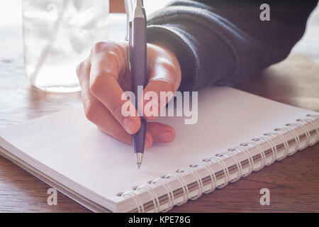 Donna mano con penna che scrive su notebook Foto Stock