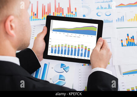 I mediatori analizzando il grafico su tavoletta digitale Foto Stock