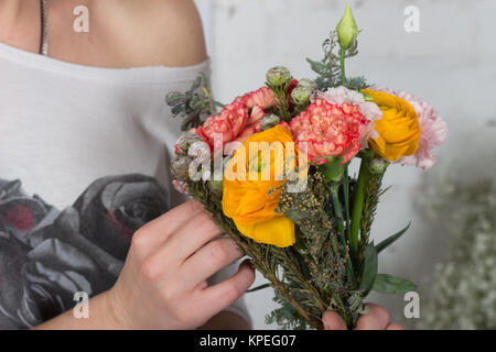 Fioraio rendendo luminosa arancione e rosa bouquet Foto Stock