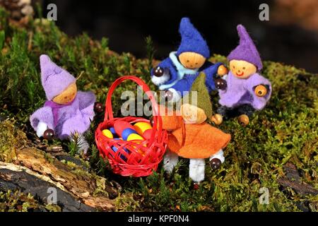 Quattro gnomi piccoli sono alla ricerca di uova di Pasqua nella foresta Foto Stock