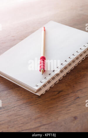 Stazione di lavoro con notebook e matita con filtro vintage Foto Stock