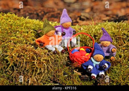 Quattro gnomi piccoli sono alla ricerca di uova di Pasqua nella foresta Foto Stock