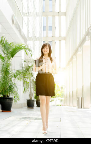 Giovane donna asiatica a piedi executive Foto Stock