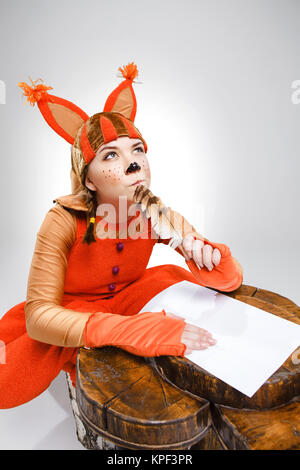 Giovane donna in immagine di scoiattolo scrivendo con la penna del cappello