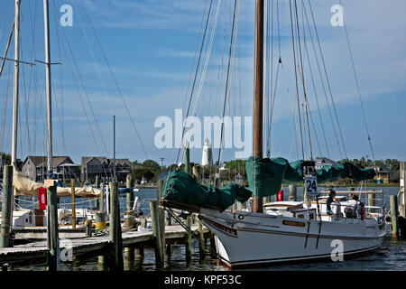 NC01074-00...North Carolina - nave a vela sul lago d'argento Harbour e il Ocracoke Island Lighthouse nella città di Ocracoke. Foto Stock