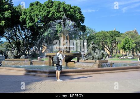 I turisti all'aperto Sydney Australia. Le persone o i turisti in Australia a piedi passato Archibald fontana commemorativa in Hyde Park a Sydney. Foto Stock