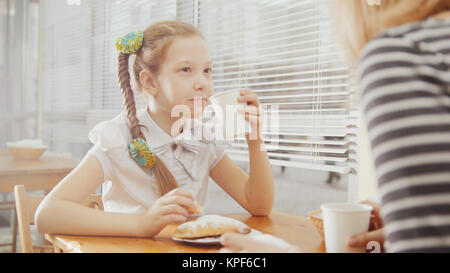 Bambina con la mamma in cafe - teen spiega qualcosa per la madre Foto Stock