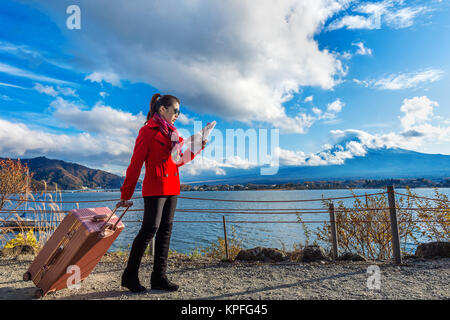 Turistico con il bagaglio e la mappa a monte Fuji, Kawaguchiko in Giappone. Foto Stock