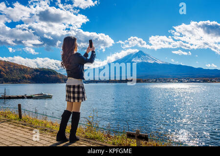 Donna utilizzare il telefono cellulare per scattare una foto al Fuji montagne lago Kawaguchiko in Giappone. Foto Stock