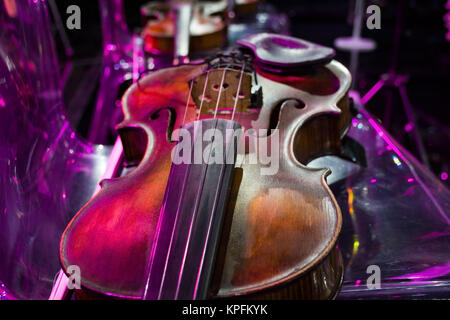 Violino in stile vintage sulla sedia sfondo colorato Foto Stock