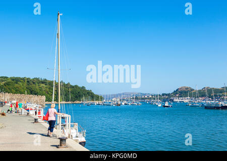 Il nord del Galles conway north Wales conwy Galles del nord a turisti e villeggianti che camminando lungo la banchina del porto di fiume di parete Conwy estuary Gwynedd uk gb Foto Stock