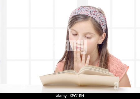 Pre teenager legge un libro Foto Stock