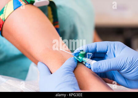 Medico o infermiere prende il sangue da donna Foto Stock