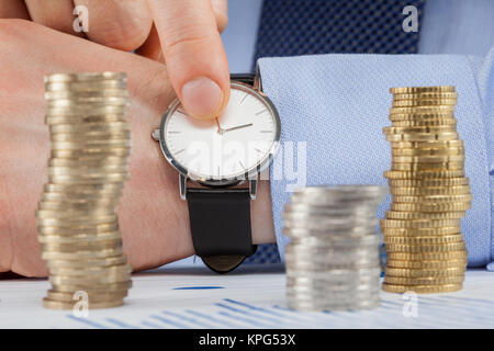 Imprenditore indicando il tempo Foto Stock