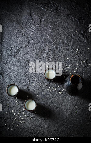 Sake bianco in ceramica nera su Black Rock Foto Stock