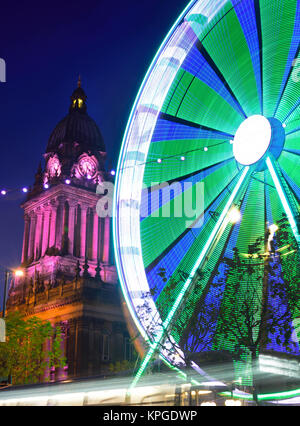 Il traffico che passa luna park e le luci di Natale da leeds town hall al crepuscolo Yorkshire Regno Unito Foto Stock