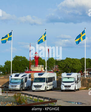 Tre bandiere Svedese battenti e tre camper, Oregrund, Svezia e Scandinavia Foto Stock