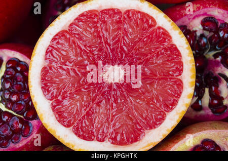 Pila di pompelmi freschi su sfondo melograni Foto Stock
