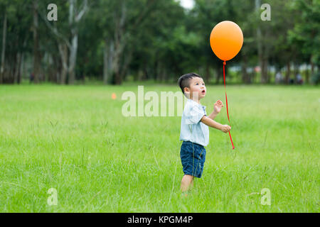 Little Boy di cattura con palloncino Foto Stock