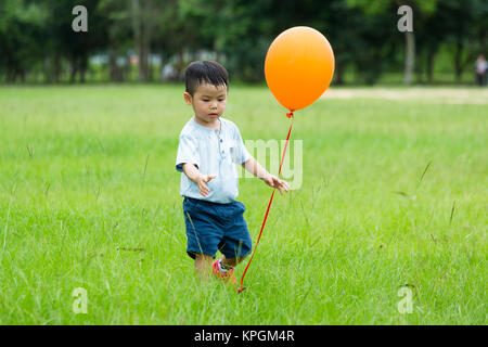 Asian little boy gioca con palloncino Foto Stock