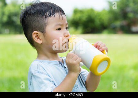 Little Boy drink con la sua acqua in bottiglia Foto Stock