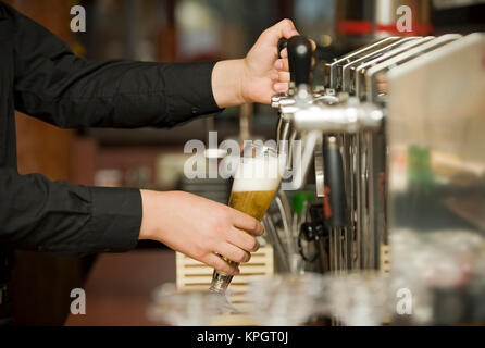 Modello rilasciato , Kellner beim Bier zapfen - cameriere Foto Stock