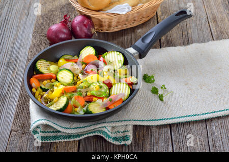 Un pasto vegano: breve misto di verdure fritte servite in una padella Foto Stock