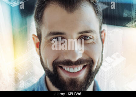 Piacevole uomo gioioso guardando dritto e divertirsi. Foto Stock