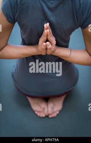 Le giovani donne a praticare yoga insieme, stanno facendo la preghiera di retromarcia pongono e stringendo le mani dietro la schiena Foto Stock