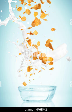 I cornflakes caduta con flusso di latte Foto Stock