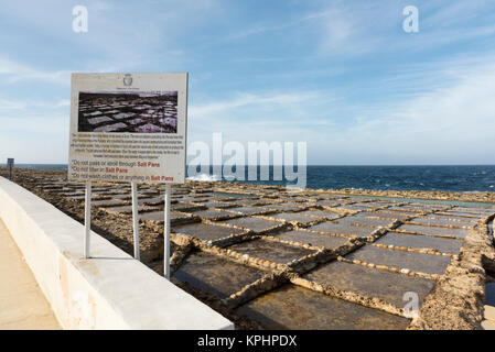 Un segnale di informazione presso saline sulla costa a Qbajjar vicino alla Baia di Marsalforn Bay Gozo Malta Foto Stock