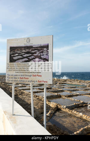 Un segnale di informazione presso saline sulla costa a Qbajjar vicino alla Baia di Marsalforn Bay Gozo Malta Foto Stock